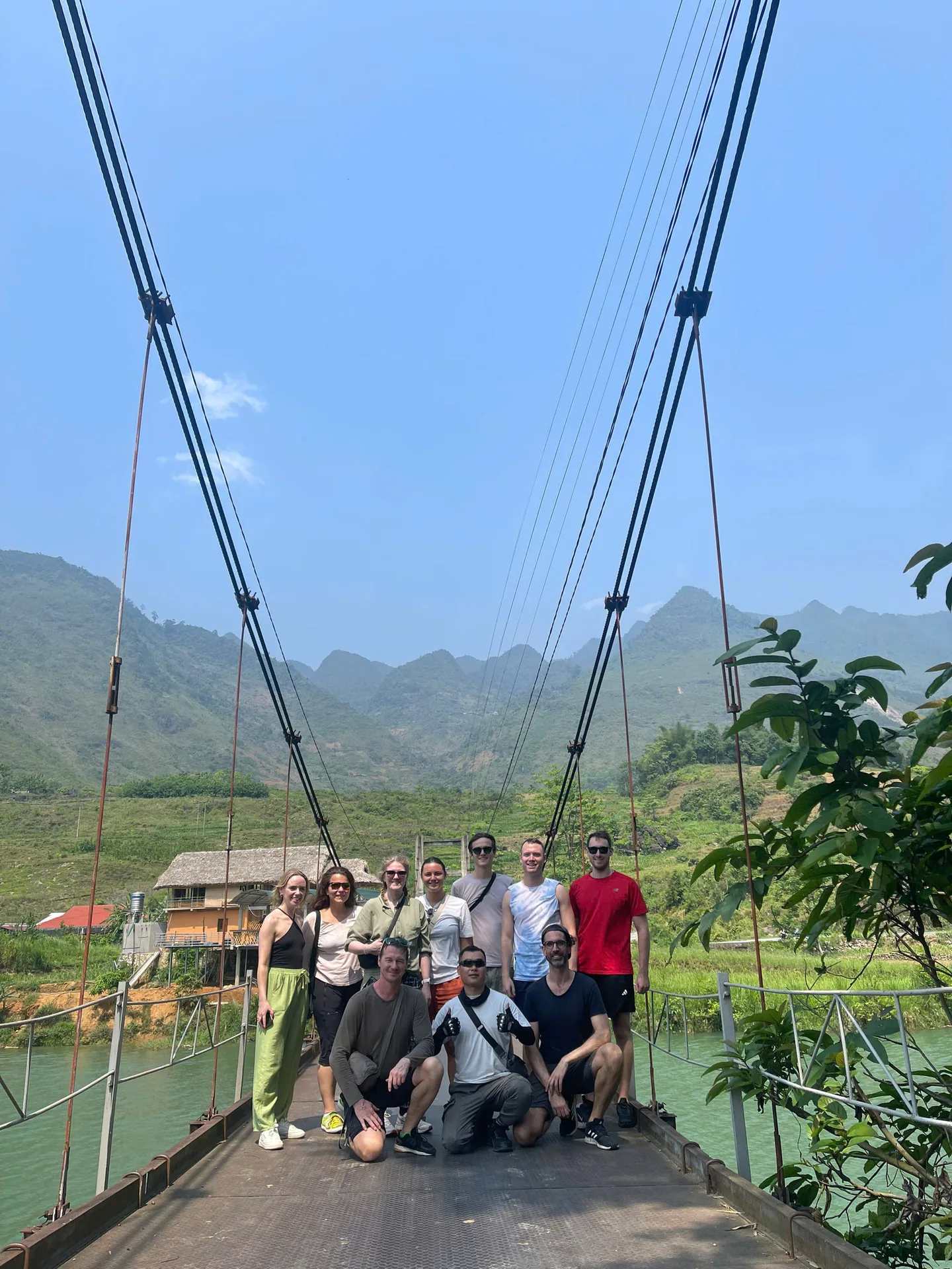 A Freedom group on a suspension bridge over a jade river