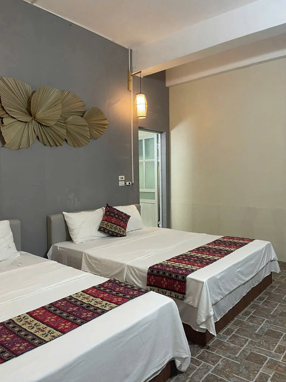 Private twin room with two double beds and brocade runners